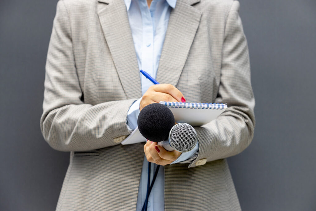 journaliste avec un bloc papier et micros