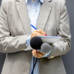 journaliste avec un bloc papier et micros